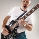 Portrait of a guitar player exciting music on gray background